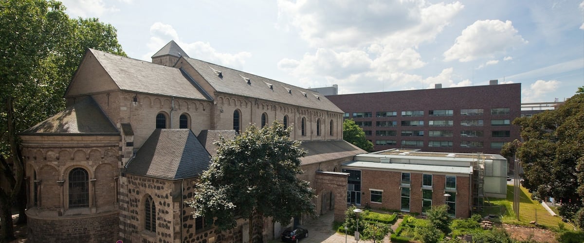 A historic building with a large courtyard, surrounded by modern architecture.