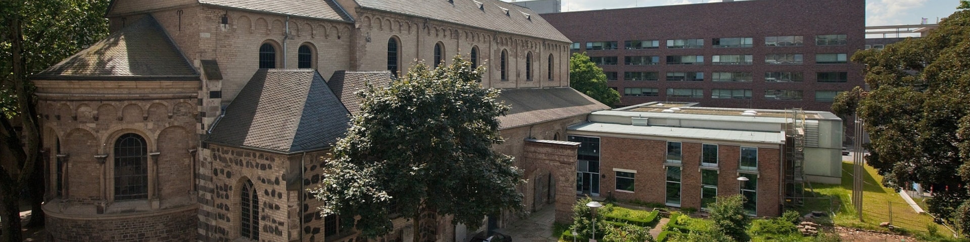 A historic building with a large courtyard, surrounded by modern architecture.