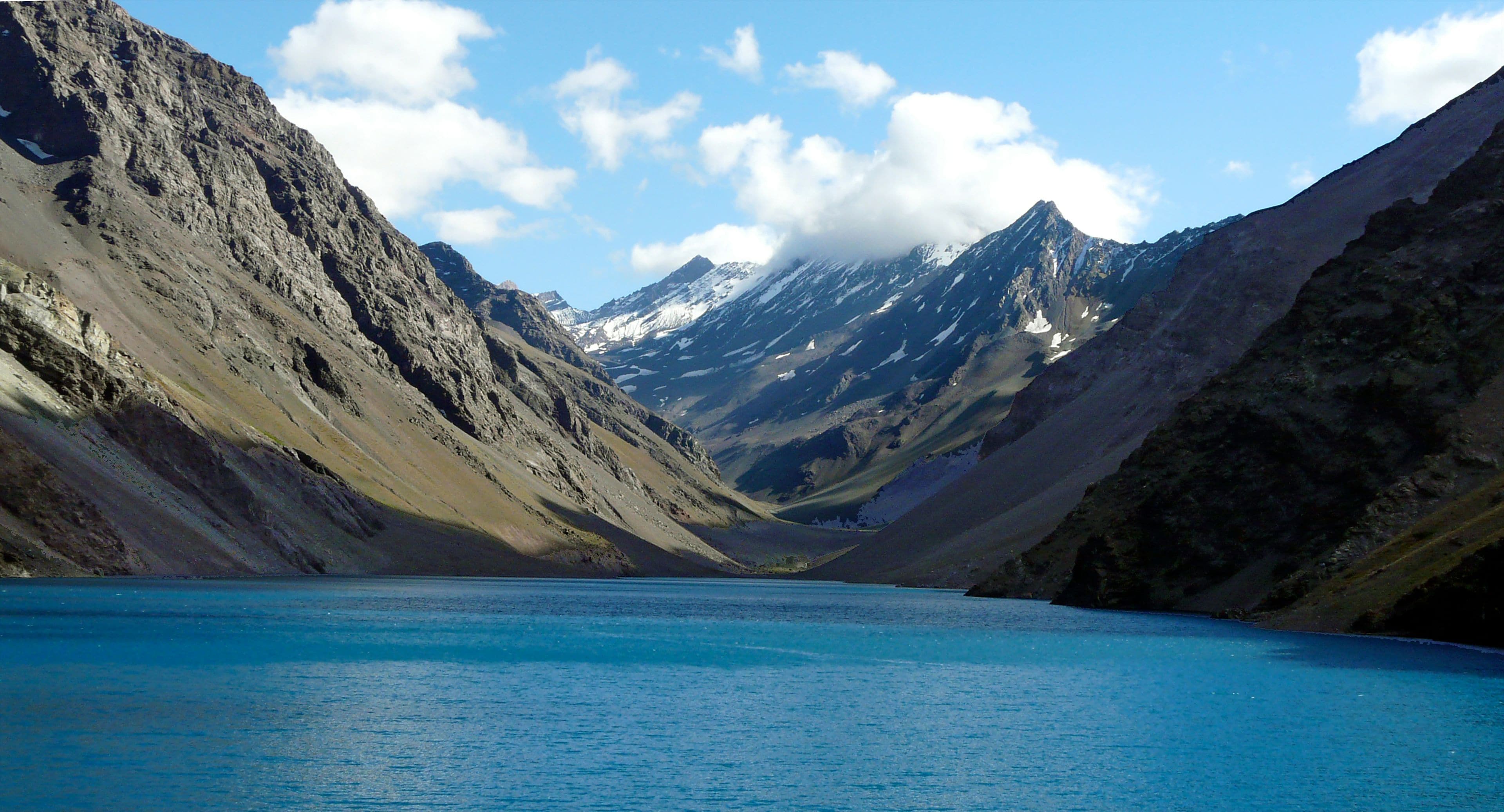 Um lago de montanha rodeado por terreno acidentado.