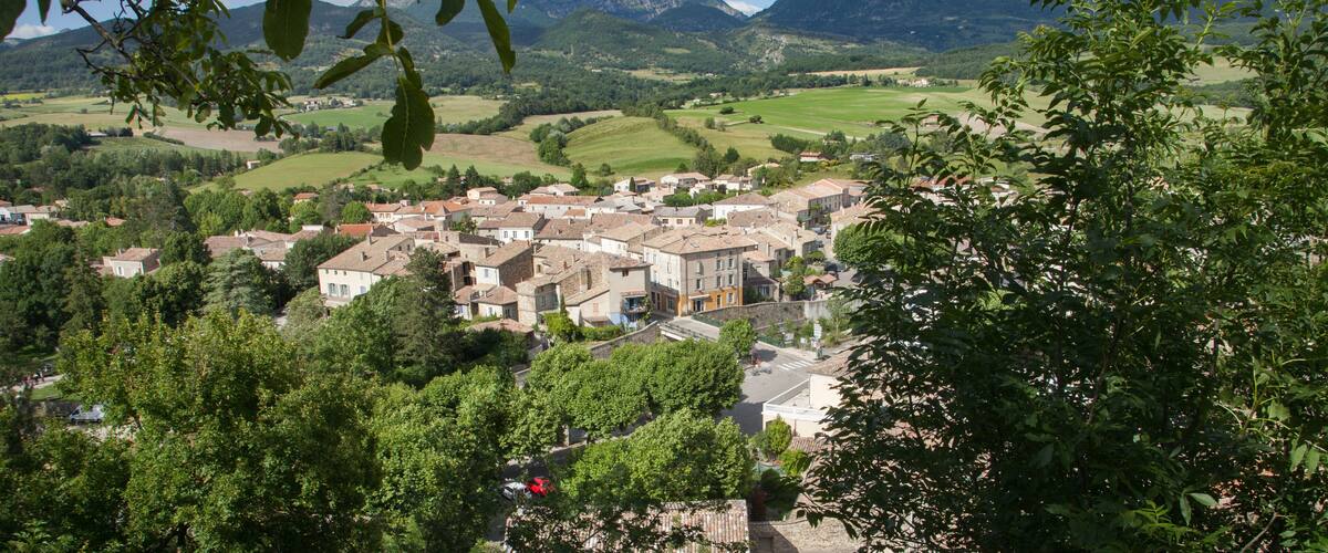 A town nestled in a valley with mountains in the background.