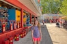 A girl standing in front of a store with a sign that reads "The Funhouse."