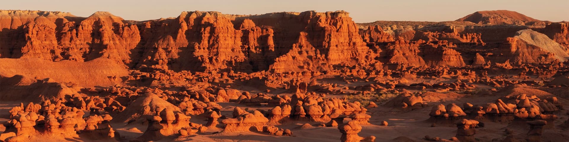 A desert landscape with prominent rock formations and a clear sky.