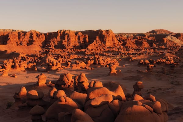 A desert landscape with prominent rock formations and a clear sky.