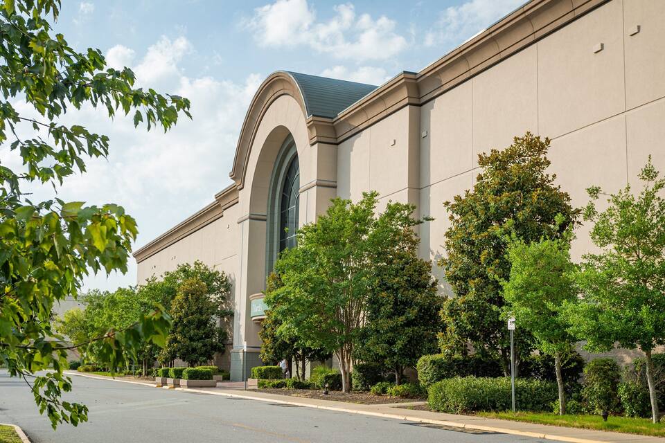 A large building with a prominent arched entrance and a green roof.