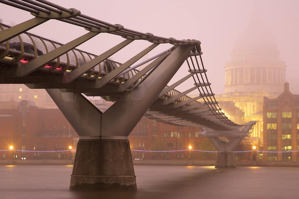 A bridge with a classical building in the background.