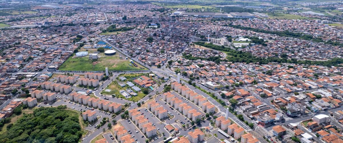 An aerial view of a densely populated city with a mix of residential and commercial buildings, a large circular structure, and a prominent tower.