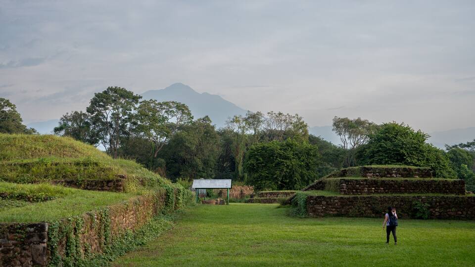 A grassy field with stone walls and a small shelter.