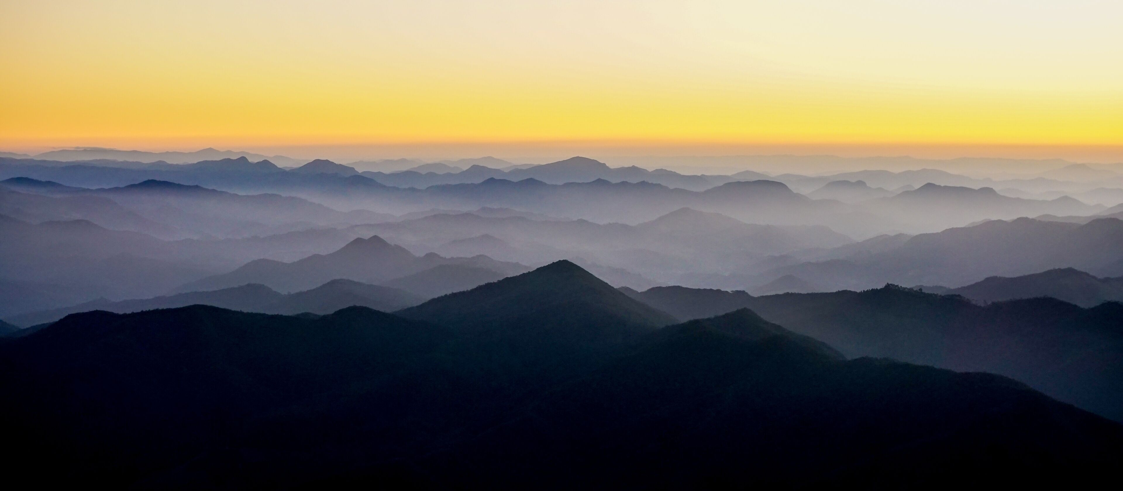 Silhouettes of the Serra da Mantiqueira's mountain range during sunset, seen from Marins Peak. Piquete, Sao Paulo, Brazil