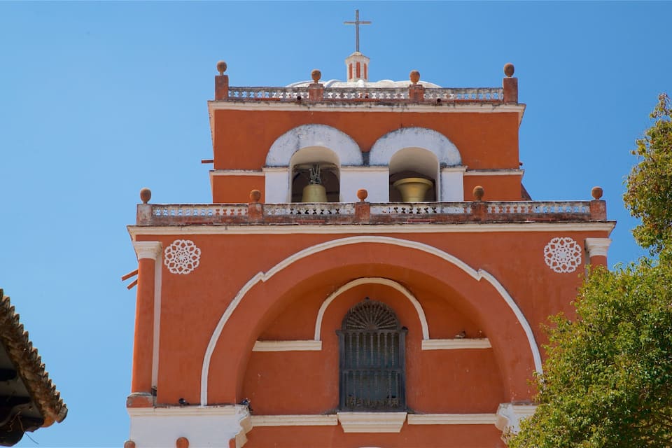 Uma igreja com uma torre de sino, porta em arco e padrões decorativos.