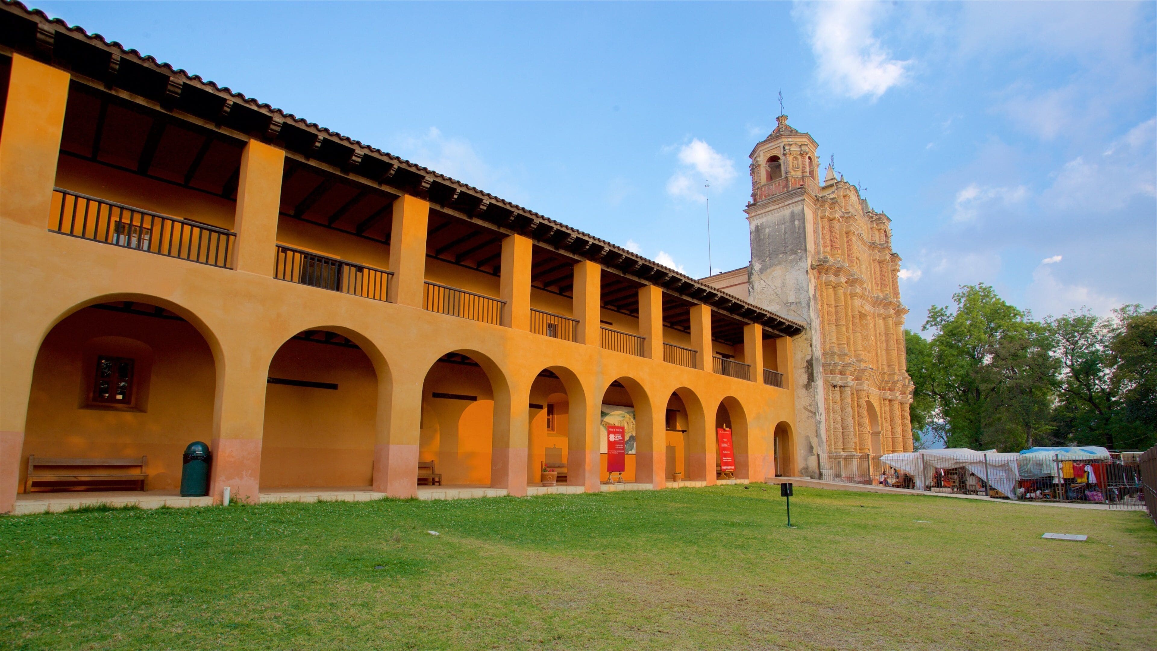 A historic building with a large tower and arched walkways.