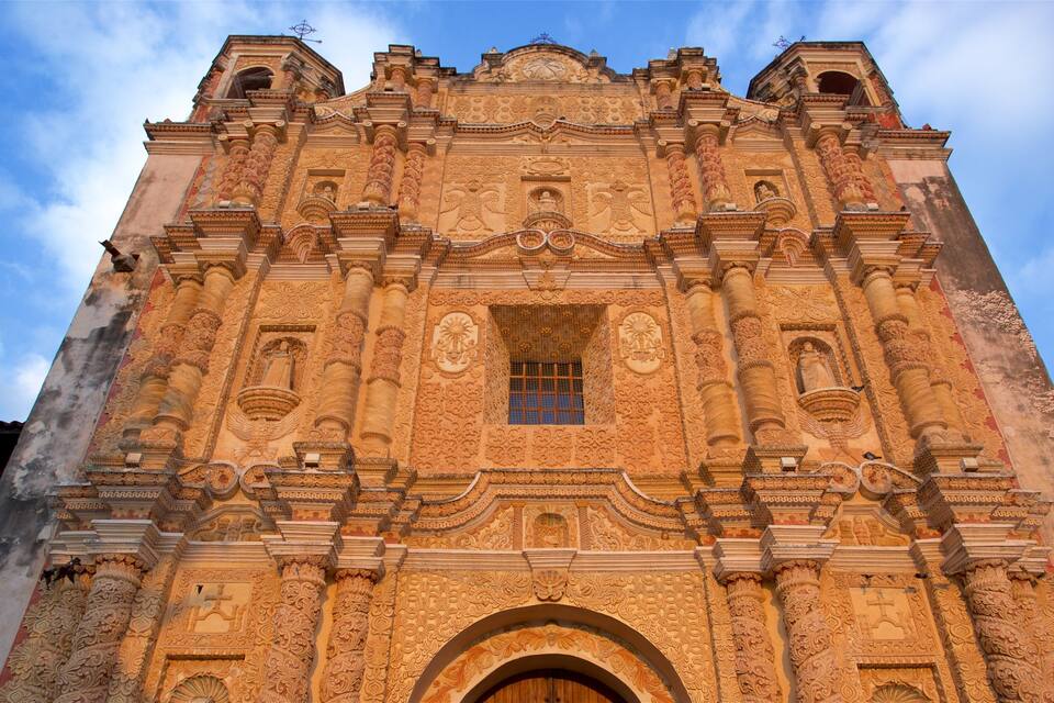 Fachada detalhada de uma igreja histórica, com esculturas elaboradas e uma grande porta central.