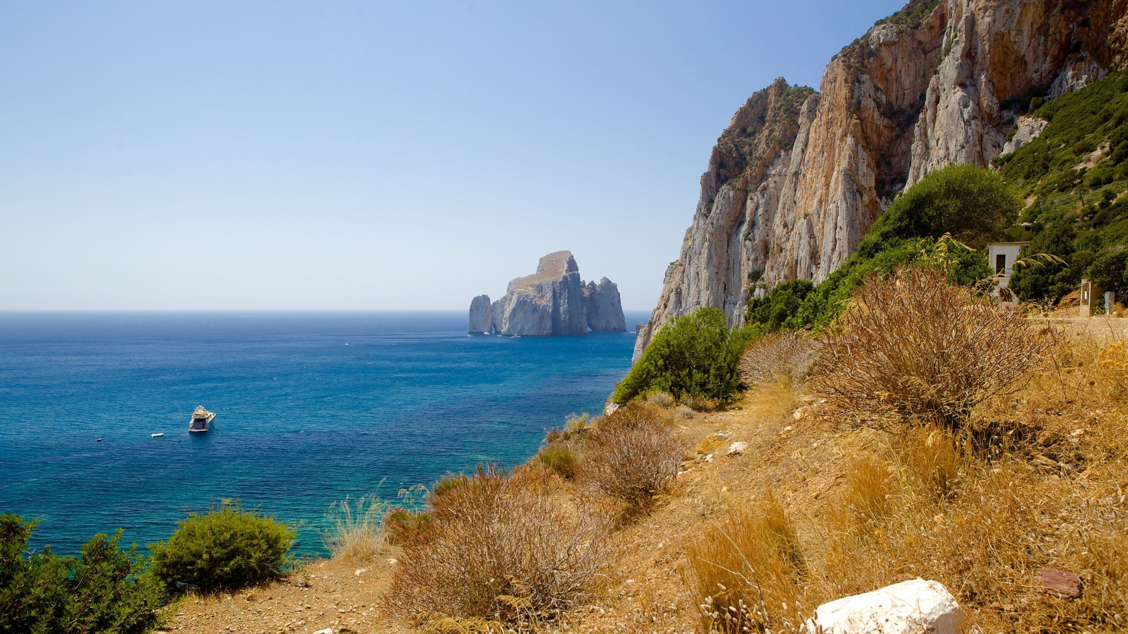 Porto Flavia som inkluderer kyst og stenete kystlinje