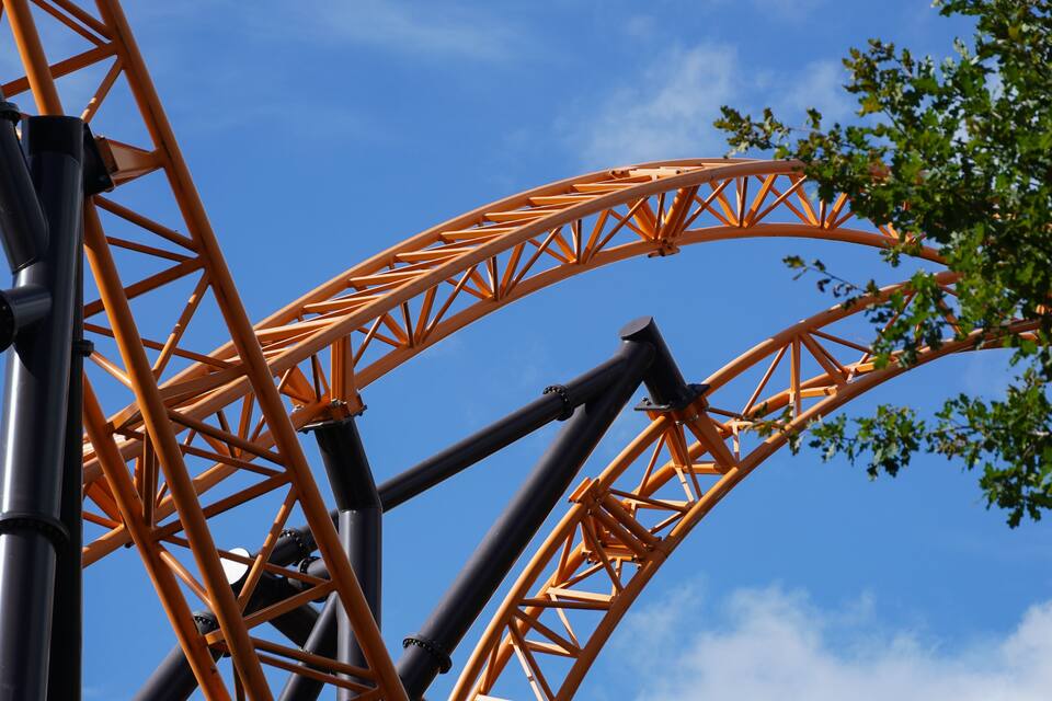 A roller coaster track with a clear blue sky in the background.