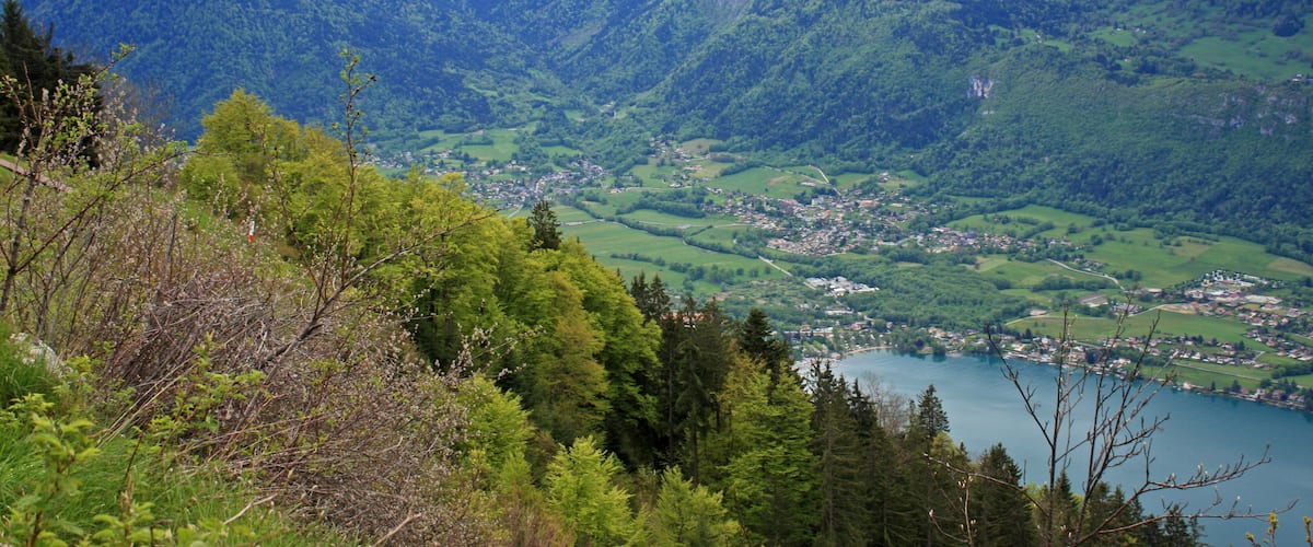 A mountainous landscape with a town and a lake.