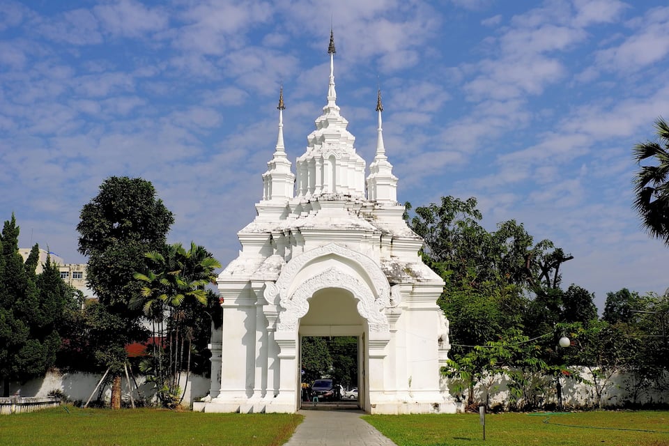 A white temple with three spires and an archway.