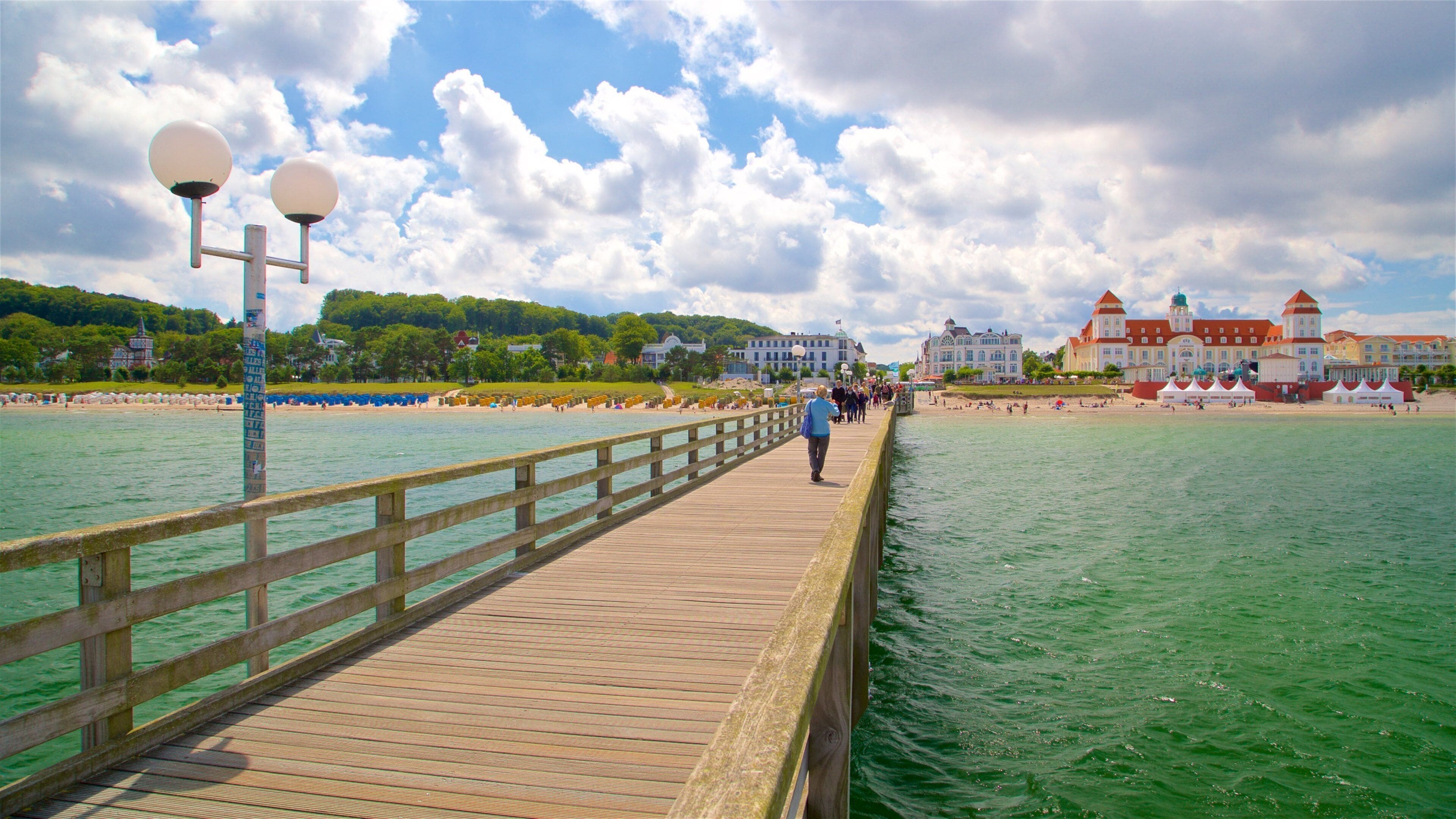 Binz Pier showing a coastal town and general coastal views as well as a small group of people