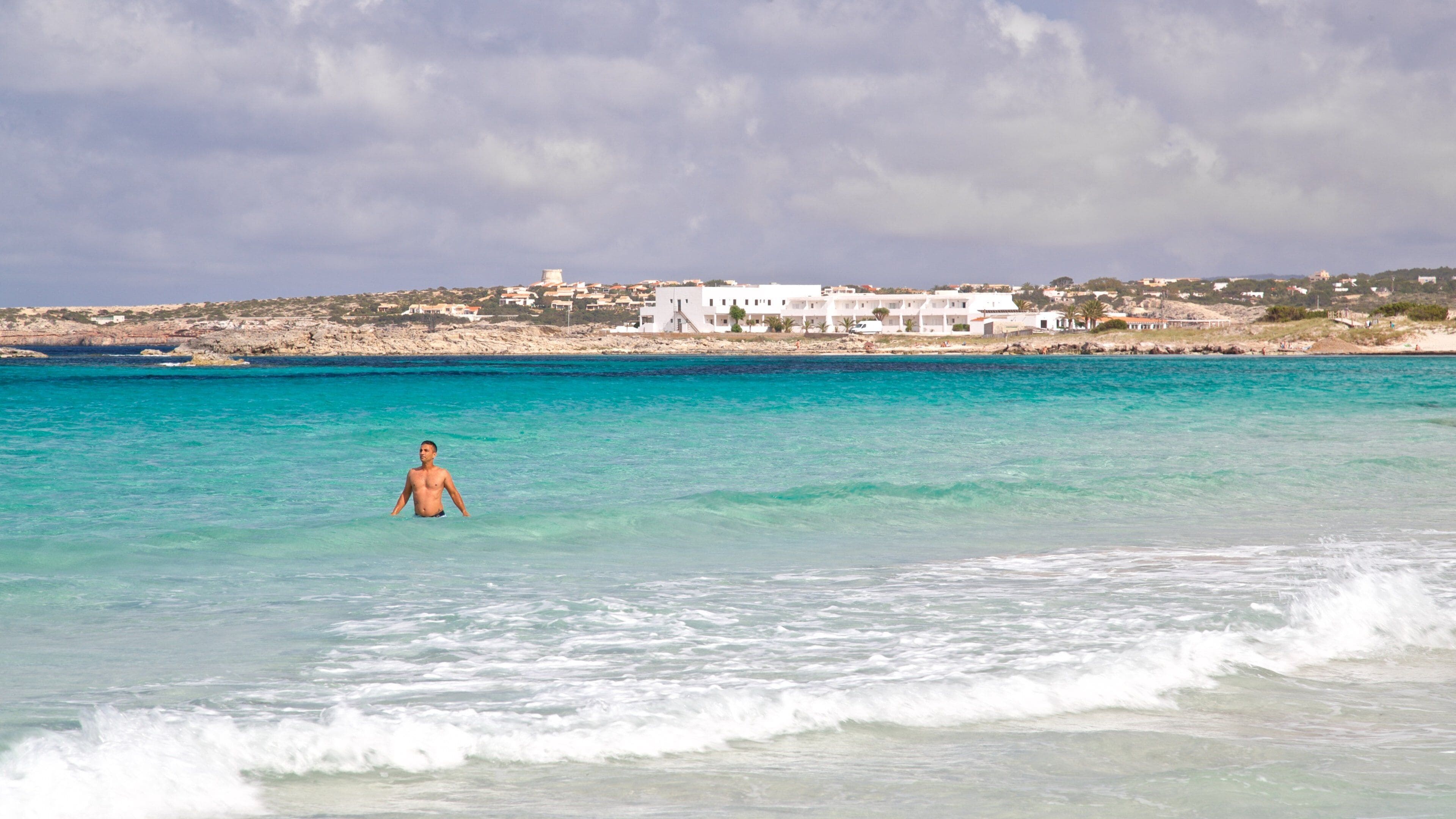 Sa Roqueta Beach which includes swimming and general coastal views as well as an individual male