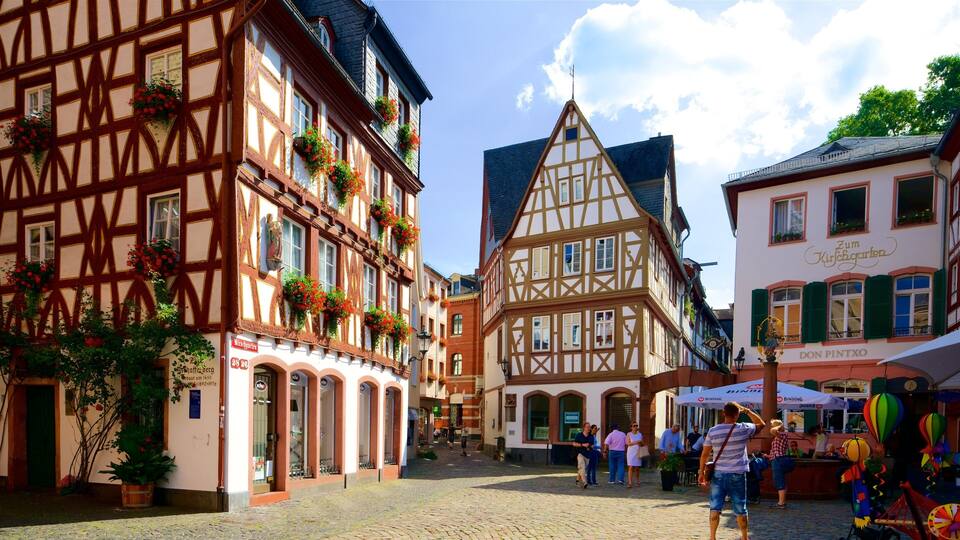 A cobblestone street lined with traditional half-timbered buildings, some with flower boxes.