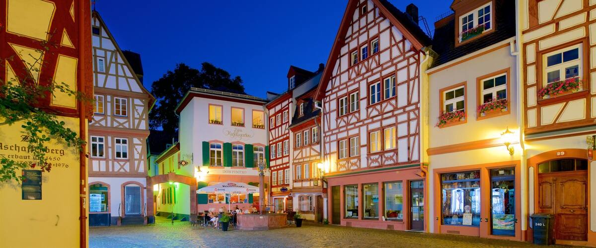 A European town square at dusk with traditional half-timbered buildings and cobblestone streets.