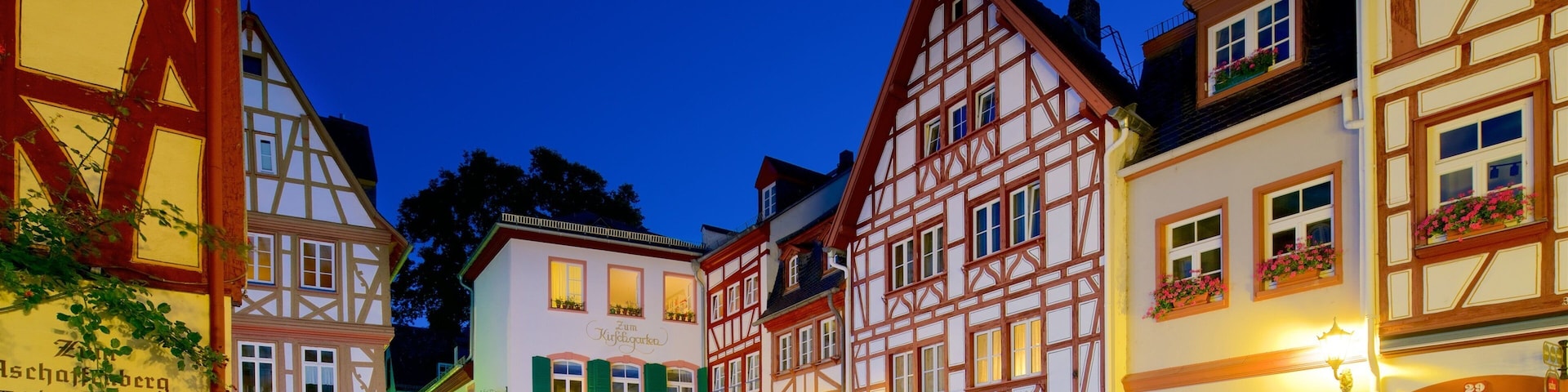 A European town square at dusk with traditional half-timbered buildings and cobblestone streets.