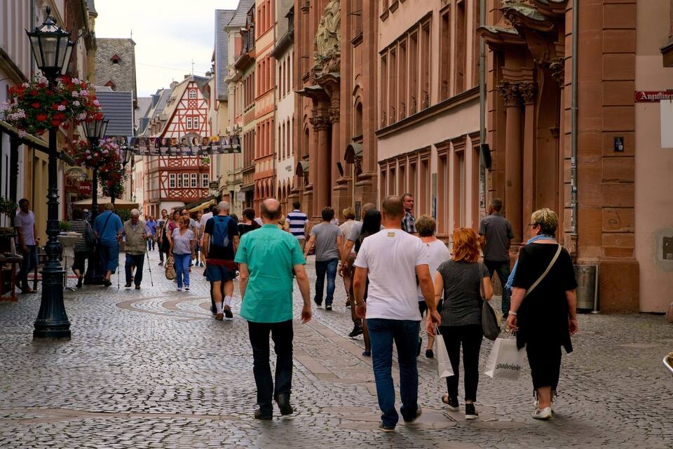 A cobblestone street lined with historic buildings and flower-adorned lampposts.