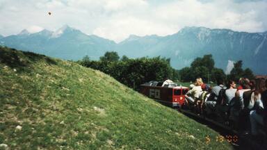 Riding on a miniature train that has a view of Mont Blanc.