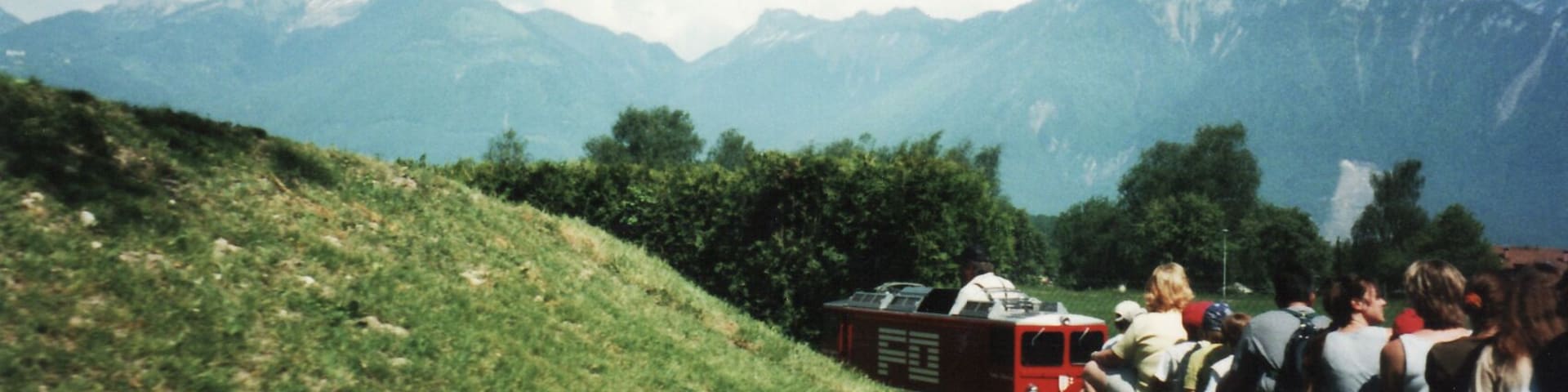 Riding on a miniature train that has a view of Mont Blanc.