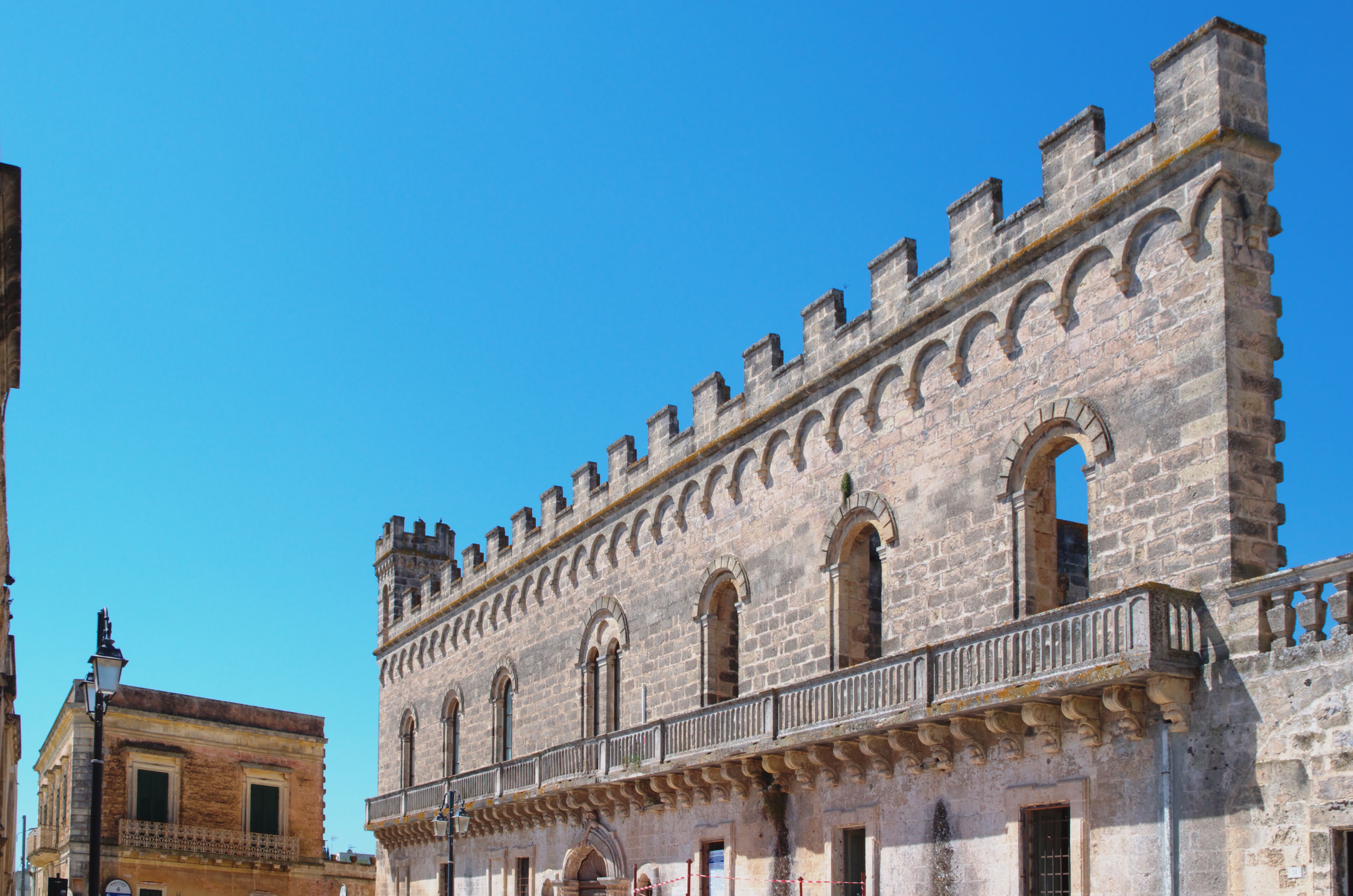 A historic stone building with arched windows and battlements.