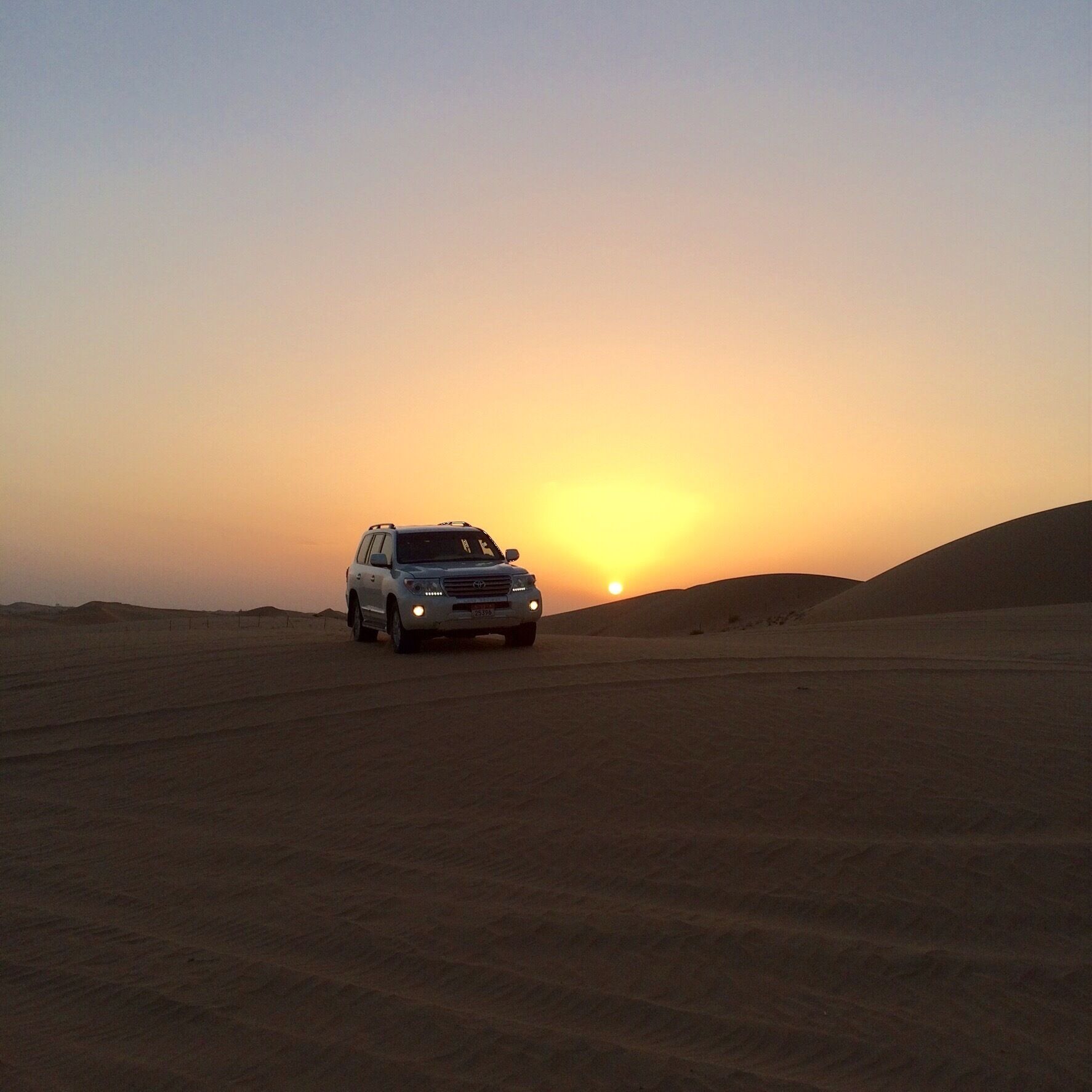 Another #throwbackphoto from last September.  
I had just been in one of these 4 wheel drive vehicles over the dunes (it was hair raising for me) and was watching the Abu Dhabi sunset when this vehicle came rolling over the hill.  
If you are ever in the UAE, experiencing the desert is great.  There are many tour operators to choose from and I did survive!
#goldenhour