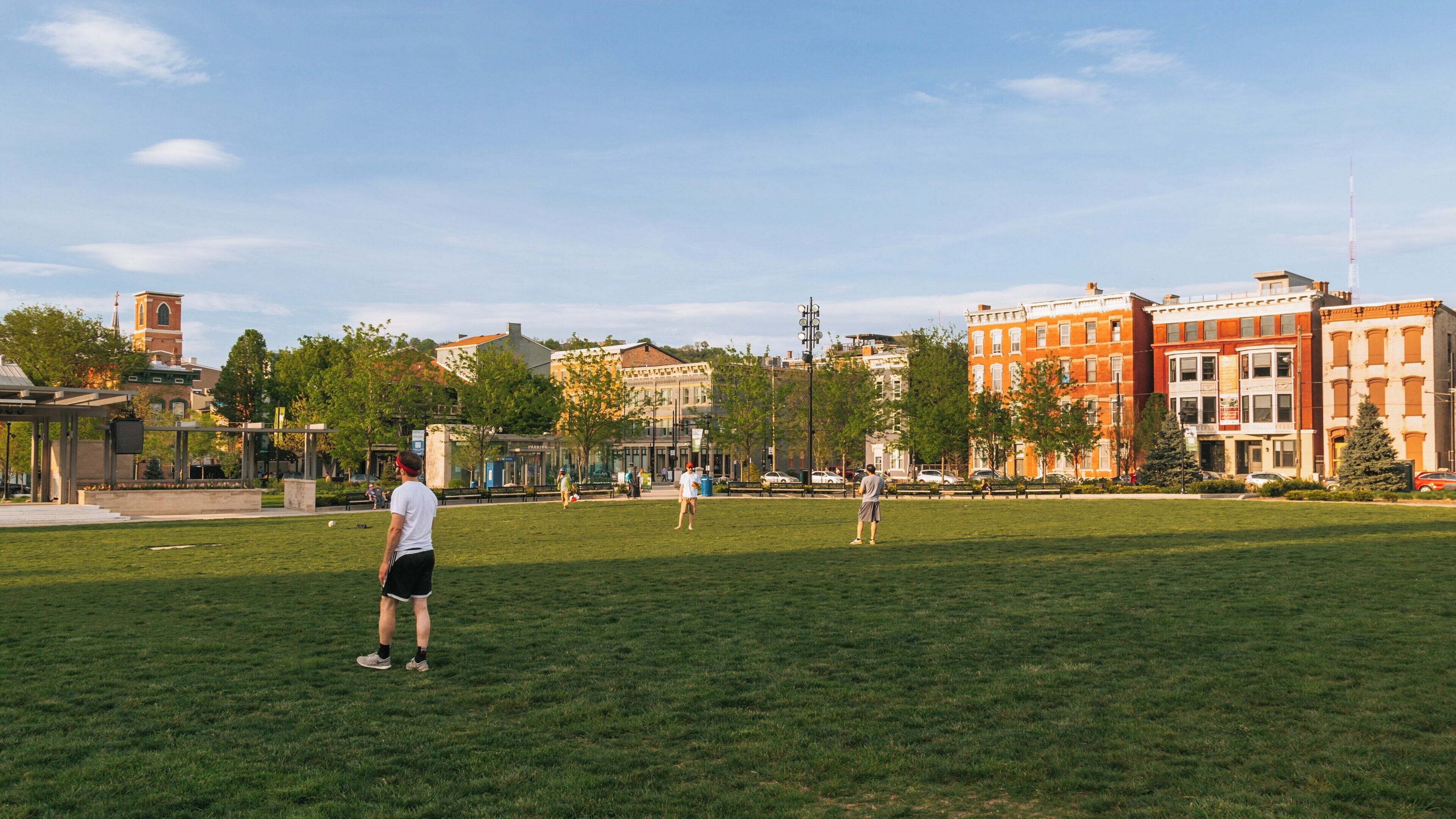 Warm afternoon at Washington Park in Over-the-Rhine, Cincinnati, filled with people enjoying leisure activities and greenery