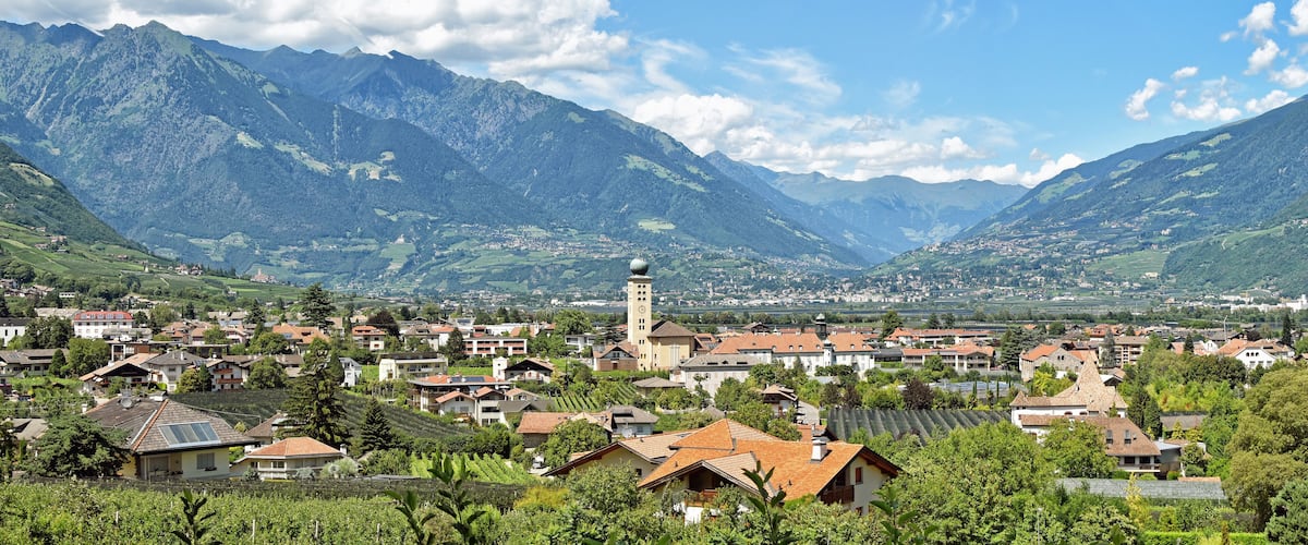 A town nestled in a valley with mountains in the background.