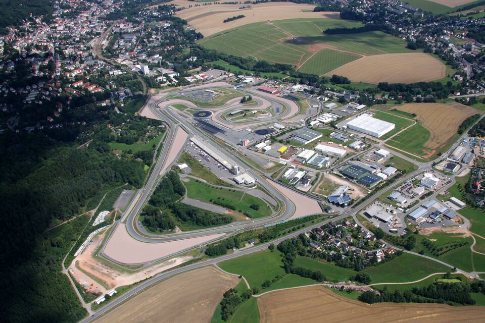 Luchtbeeld van een racecircuit, omringd door woonwijken en akkerland.