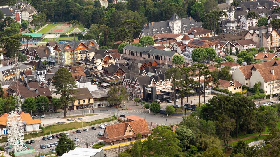 An aerial view of a town with a mix of traditional and modern architecture, a prominent church, and a sports field.