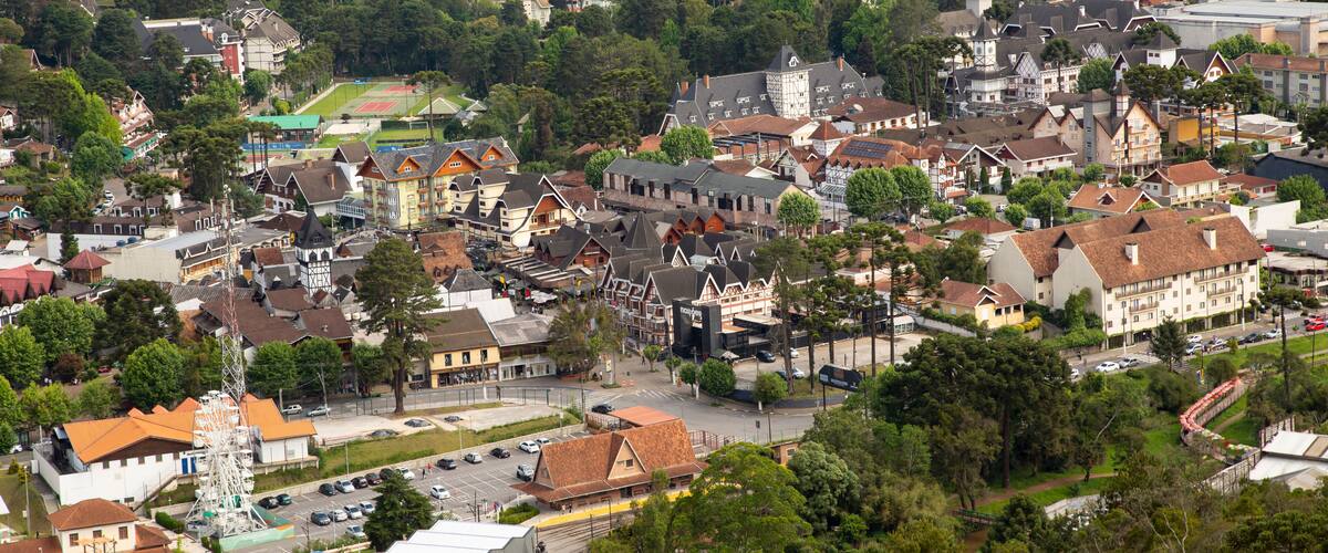 An aerial view of a town with a mix of traditional and modern architecture, a prominent church, and a sports field.
