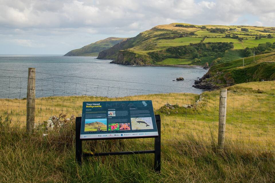 Paisaje costero con un cartel que anuncia Torr Head Ballycastle.