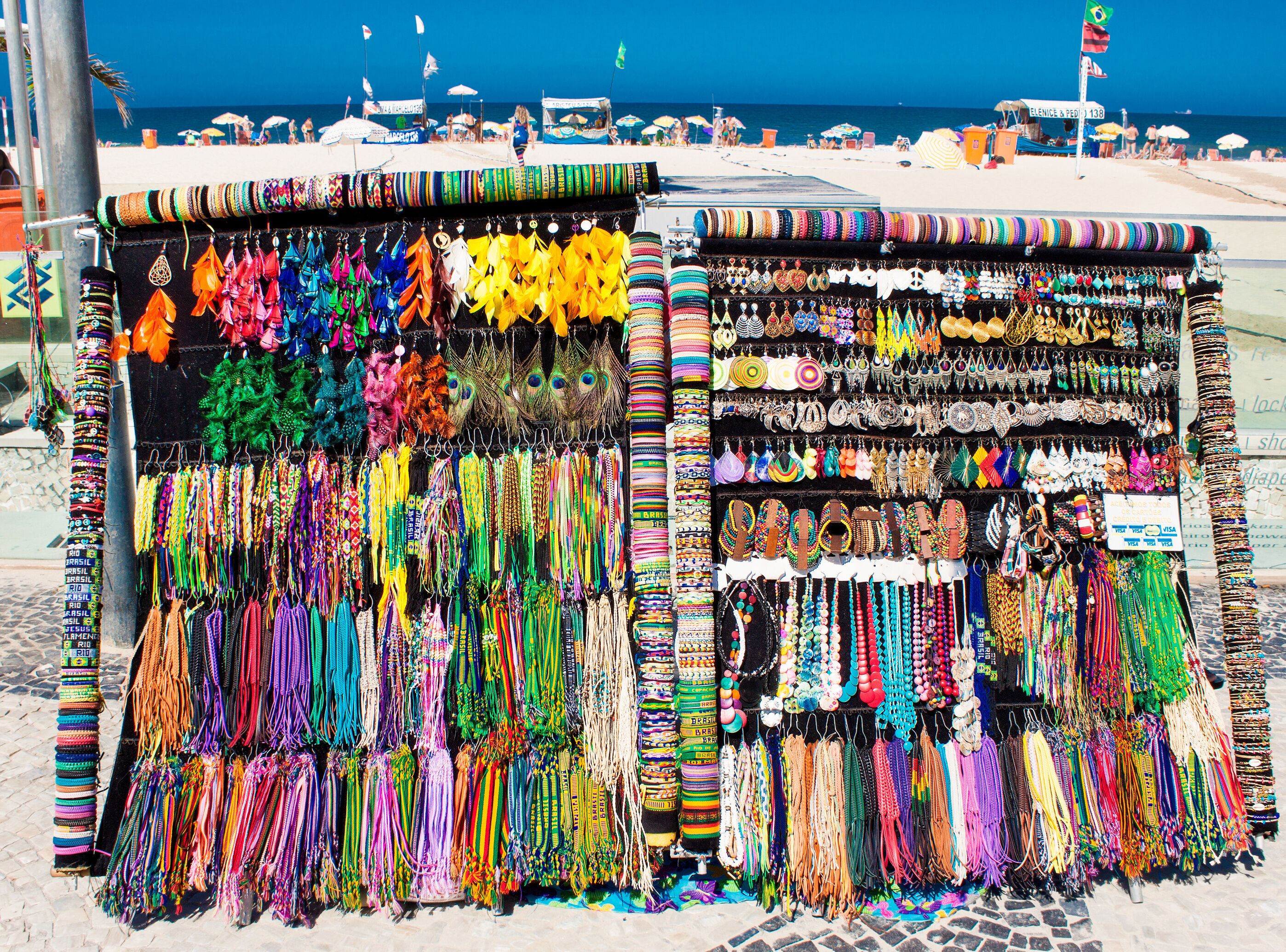 Uma loja de joias à beira-mar com diversos colares e pulseiras coloridas.