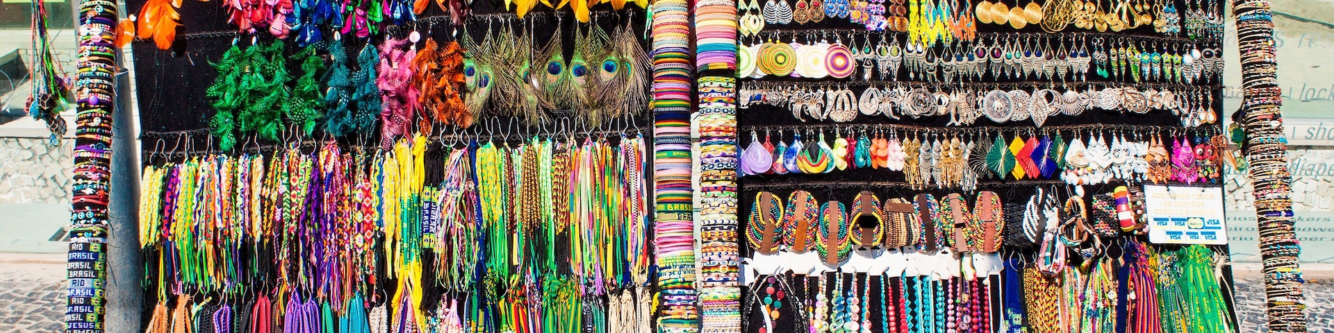 Uma loja de joias à beira-mar com diversos colares e pulseiras coloridas.