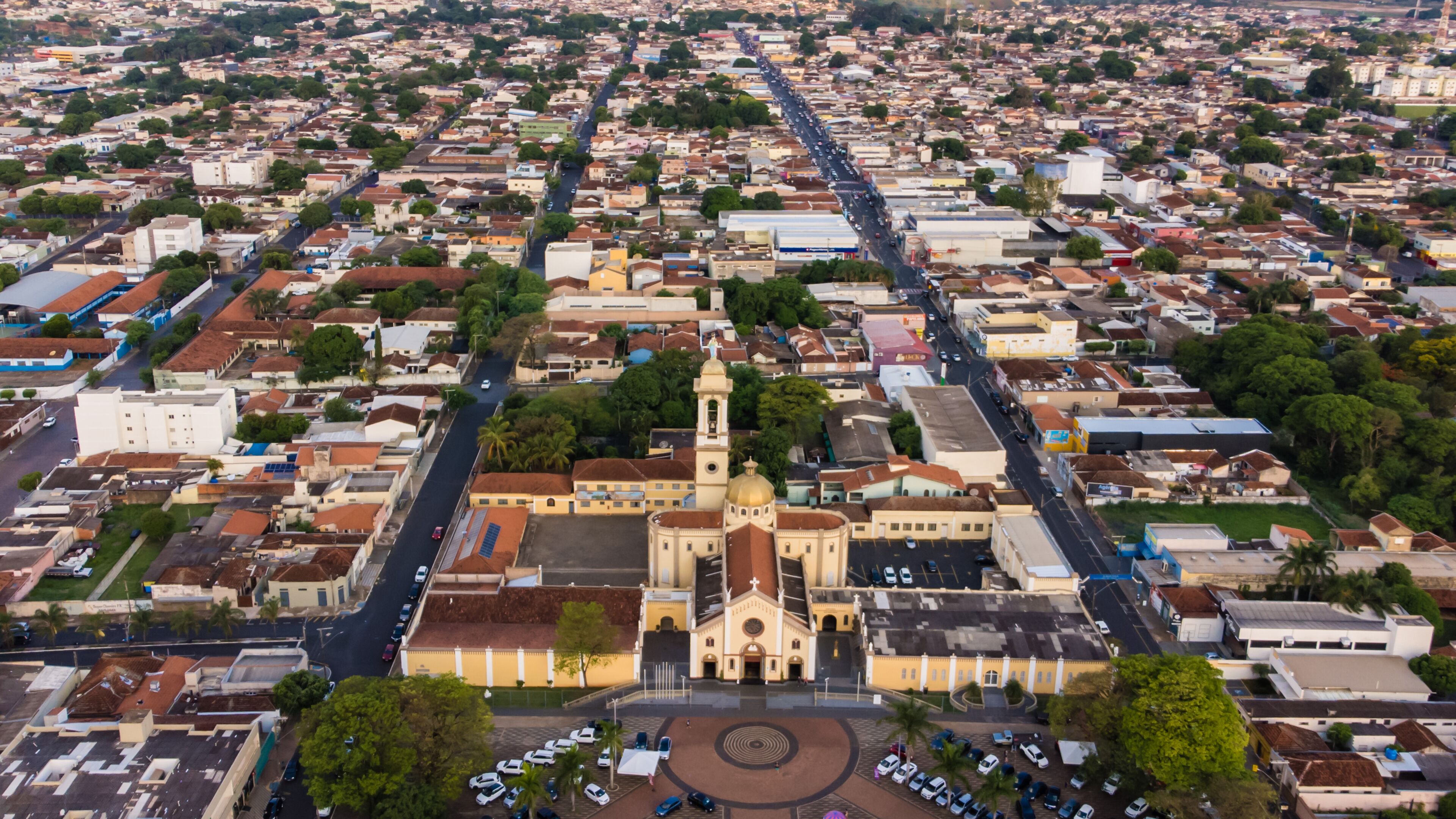 An aerial view of a city with a prominent church with a golden dome and a tall bell tower.