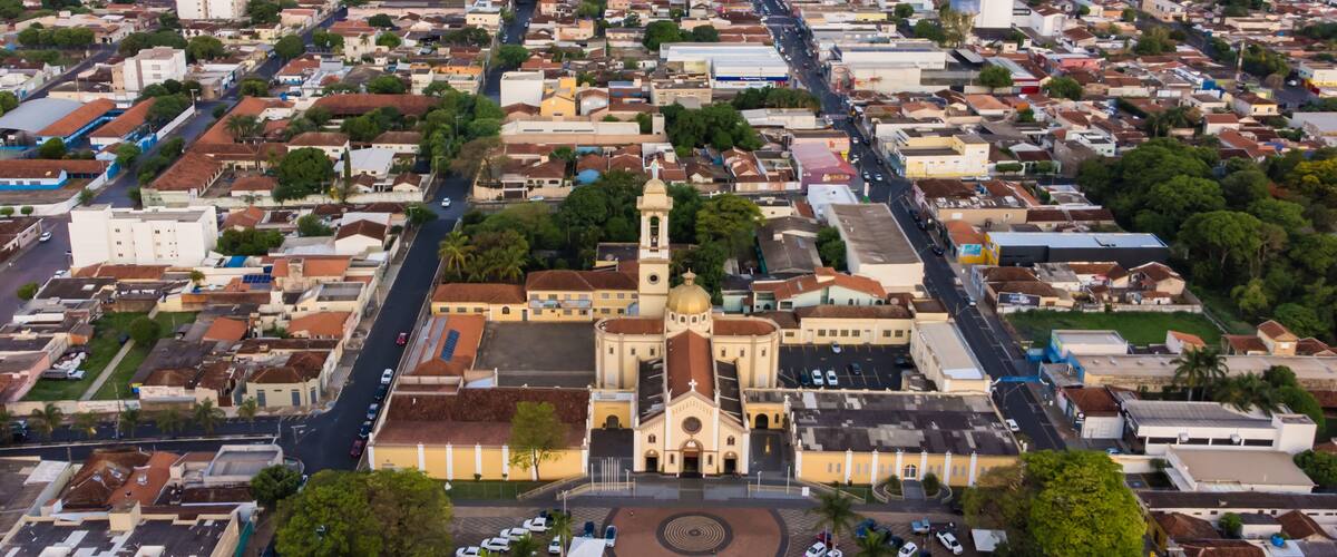 An aerial view of a city with a prominent church with a golden dome and a tall bell tower.