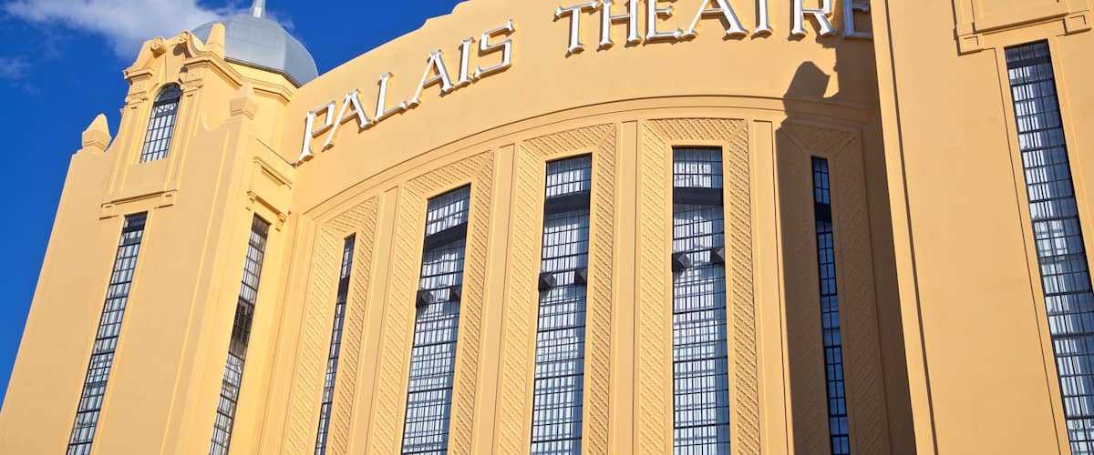 A large building with the sign "PALACE THEATRE" on its facade.