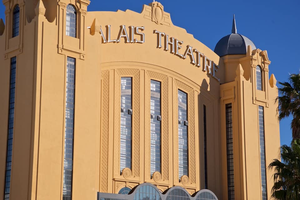 The exterior of the LAIS Theatre with its distinctive architecture and palm trees.