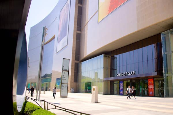 Un bâtiment moderne doté de grandes fenêtres en verre et d’une enseigne indiquant « SHINSEGAE ».