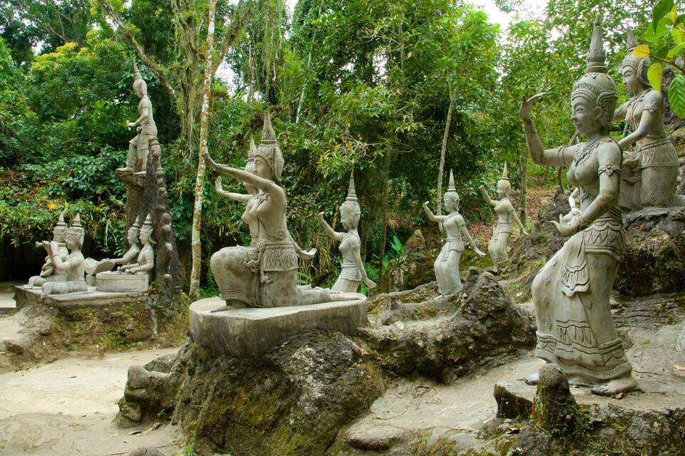 A collection of stone statues in a forested area.