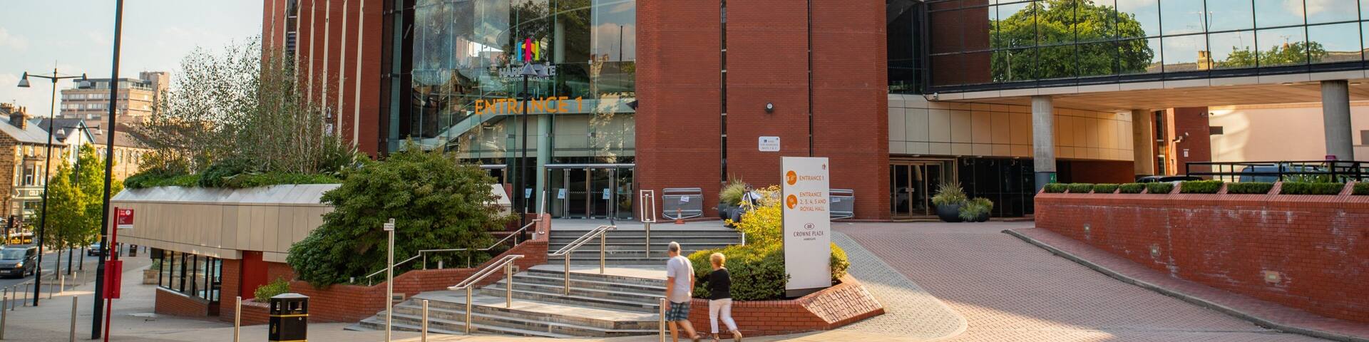 A modern building with a curved facade, large glass windows, and a prominent entrance.