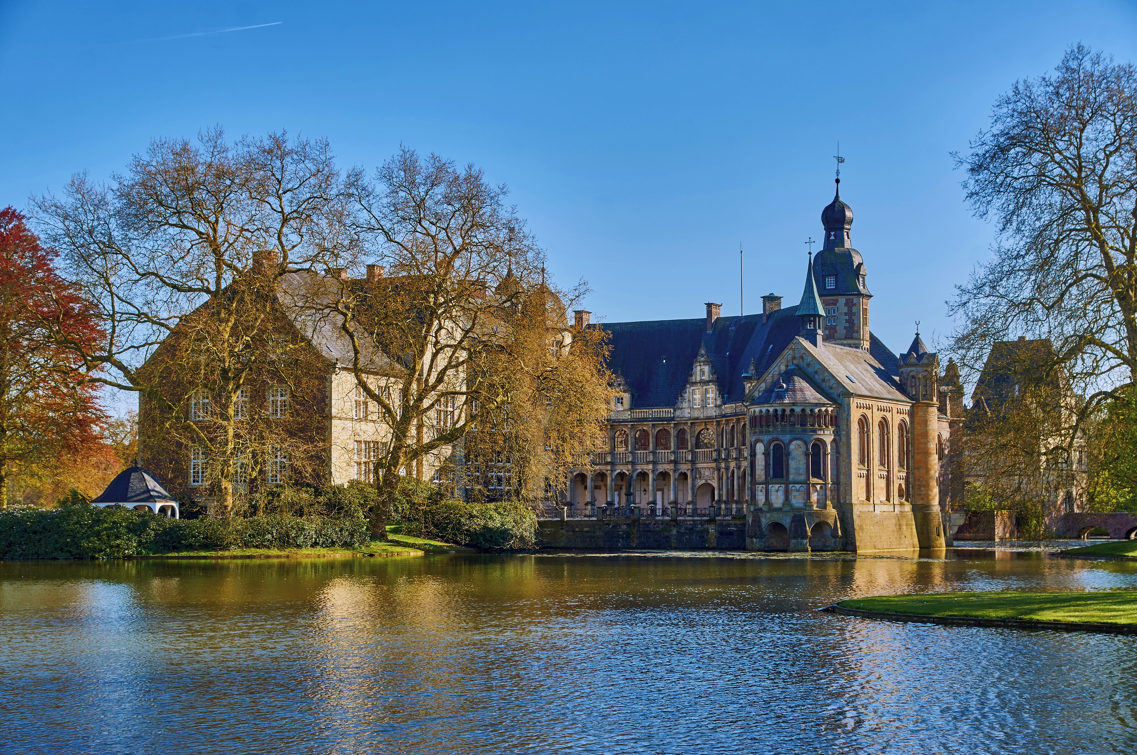A historic building with a prominent tower and a reflection in the water.