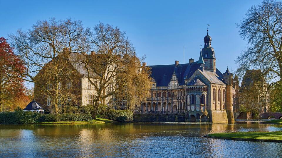 A historic building with a prominent tower and a reflection in the water.
