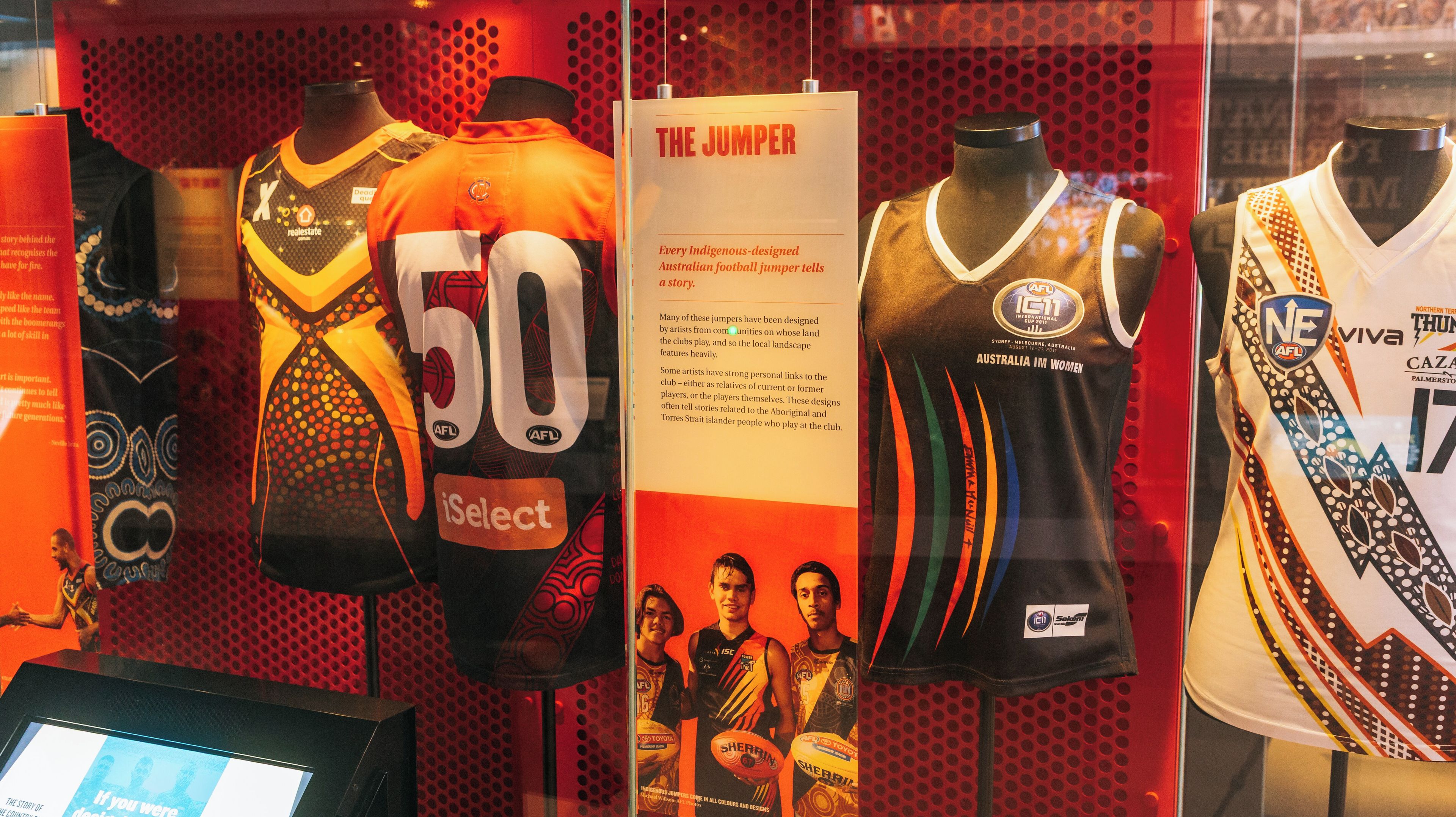 Esposizione di maglie da football australiano con motivi ispirati alle culture indigene.