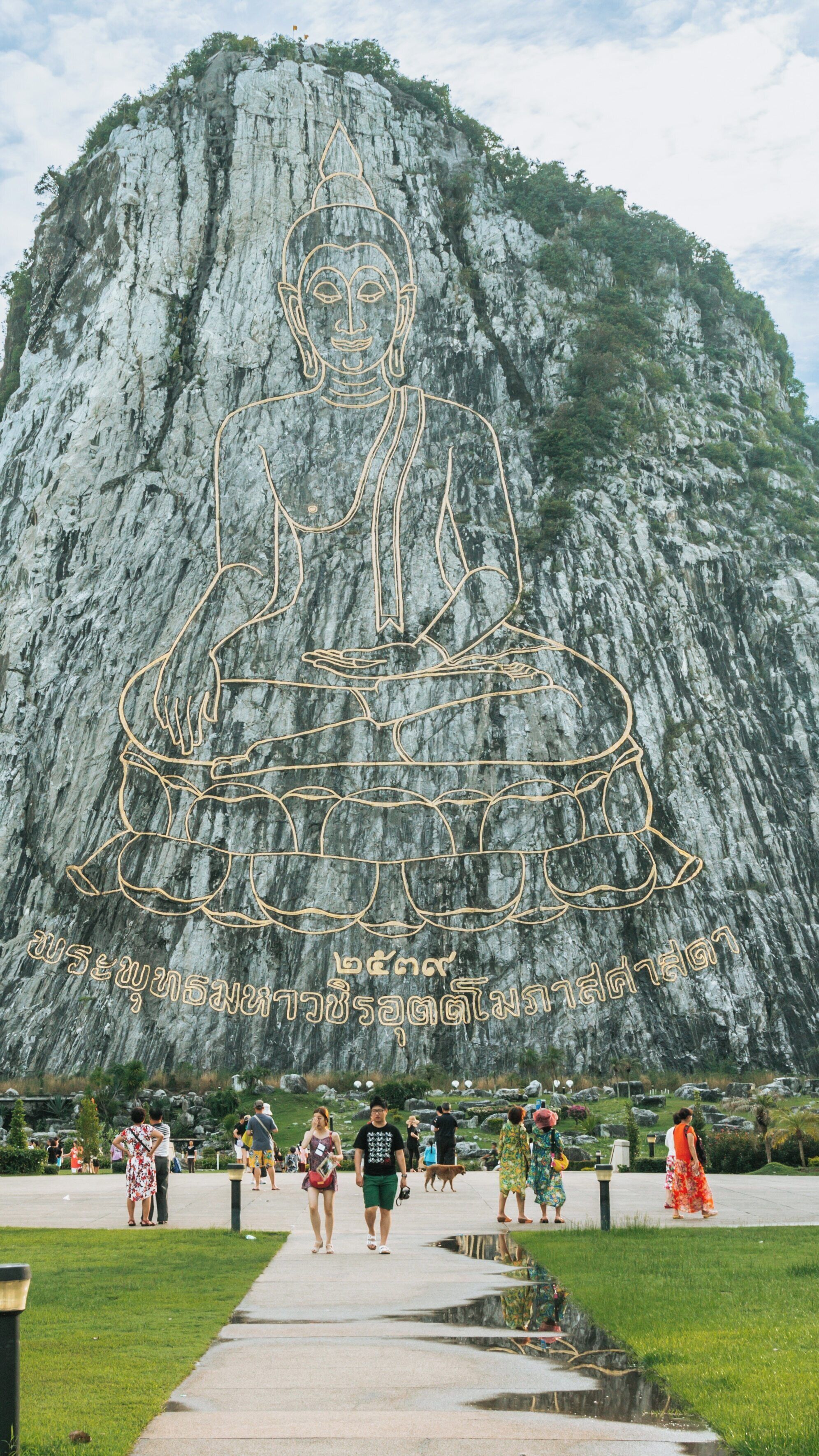 Buddha Mountain features a massive golden engraving of Buddha overlooking visitors, providing a serene atmosphere in Na Chom Thian, Sattahip, Chonburi Province, Thailand