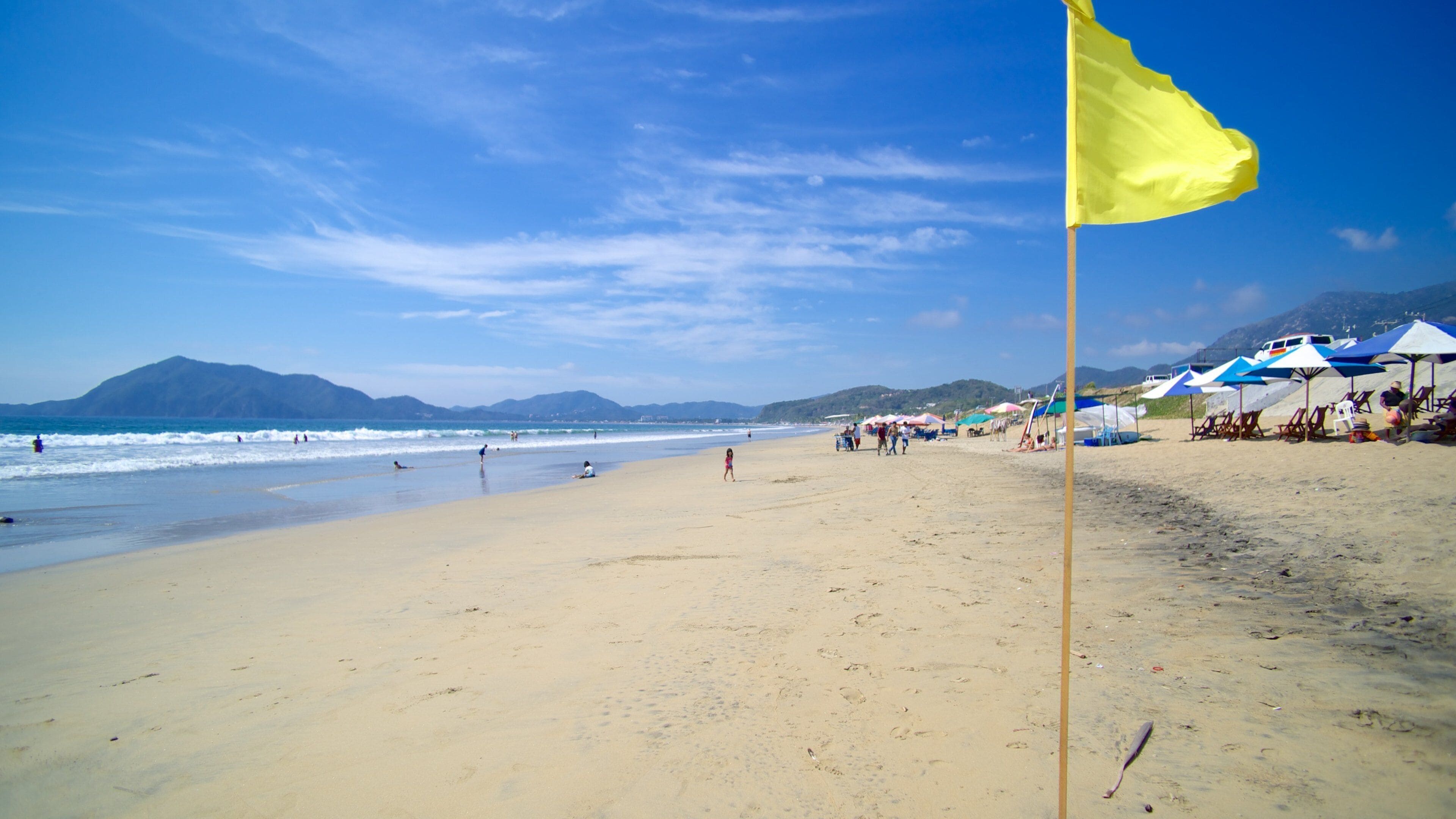 Mexico som viser en sandstrand og en bugt eller havn såvel som en lille gruppe mennesker