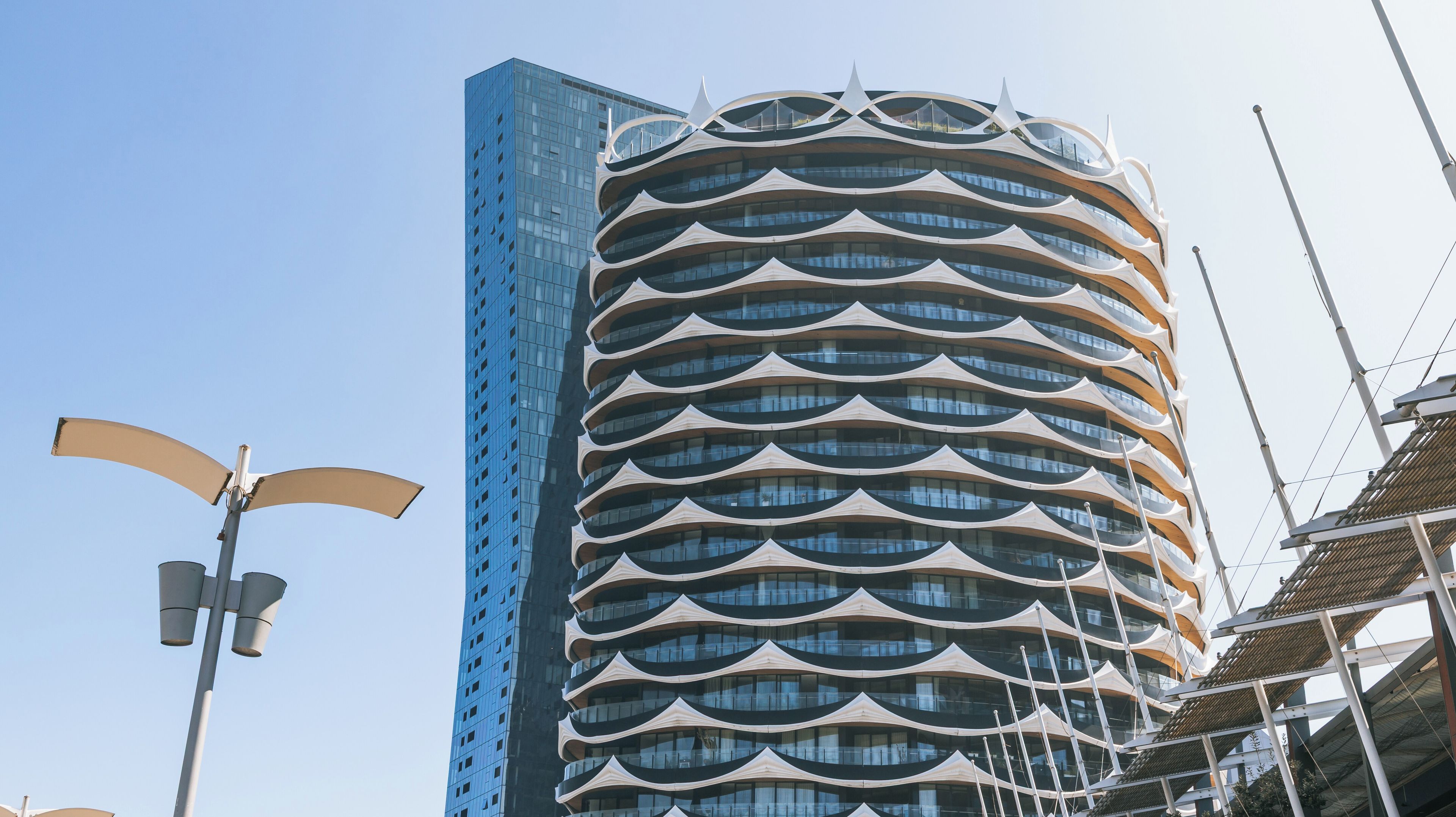 A modern building with a curved facade and a blue glass exterior.
